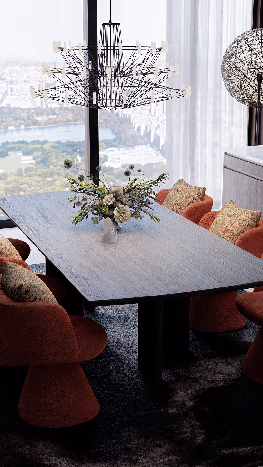 A uniquely sculptural pendant light serves as a visual focal point, drawing the eye and anchoring the space with artistic intent. The dining chairs were selected for their soft textures and refined curves, enhancing the atmosphere with both warmth and sophistication. To create a sense of material balance, rich leather surfaces are paired with cool metal and transparent glass elements resulting in a dining area that seamlessly blends contrast, elegance, and spatial harmony.