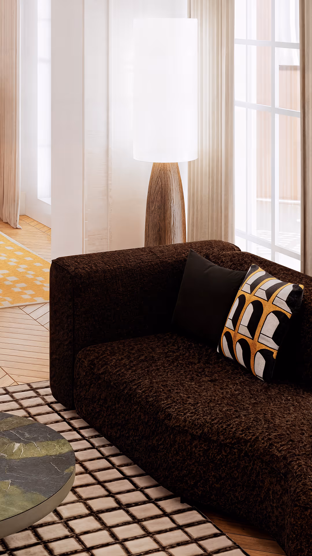 For this living area, a fabric-upholstered sofa in a deep brown tone was selected to bring warmth, tactility, and balance to the space. The textured fabric enhances visual softness while providing a comfortable, inviting seating experience. Brown serves as an anchoring color within the overall neutral palette complementing the surrounding beige, ivory, and natural wood tones to establish a harmonious and grounded visual composition. Paired with mustard and black accent pillows, the sofa introduces subtle contrast and adds depth without overwhelming the environment. This choice successfully combines aesthetic refinement with functional comfort, positioning the sofa as a key element in creating a well-balanced, high-end social living zone.